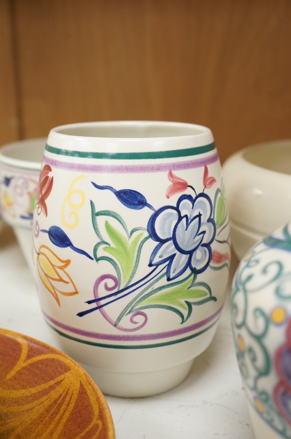 A collection of eight Poole pottery pieces to include vases, bowls and a jar and cover, largest 28cm in diameter